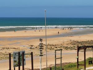 a beach with people walking on the sand and the ocean at See-Struis in Stilbaai