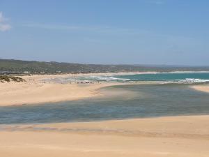 a beach with a group of people in the water at See-Struis in Stilbaai +4 photos