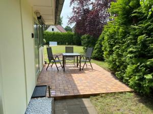 a patio with a table and chairs next to a house at Bungalow Guilietta in Göhren-Lebbin