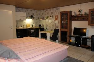 een slaapkamer met een bed en een keuken met een tafel bij Nettes Appartement in Mönchengladbach