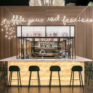 a bar with four stools in front of it at Naumi Auckland Airport Hotel in Auckland