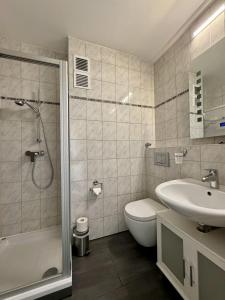 La salle de bains est pourvue d'un lavabo, de toilettes et d'une douche. dans l'établissement Haus Atlantic Whg. 514, à Cuxhaven