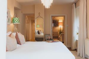 una camera da letto con un grande letto bianco e uno specchio di No 15 by GuestHouse, Bath a Bath