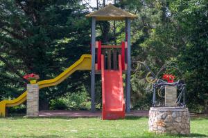 a park with a playground with a slide at Olga Rooms in Kanali