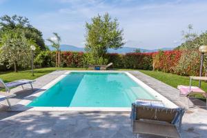 uma piscina num quintal com duas cadeiras de jardim em Villa Moderna Resort em Borgo San Lorenzo