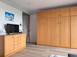 a living room with wooden cabinets and a flat screen tv at Haus Atlantic Whg. 514 in Cuxhaven