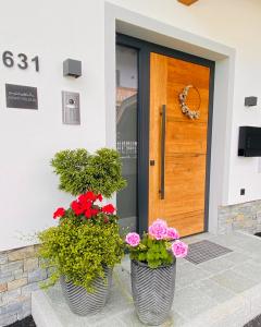 deux vases remplis de fleurs devant une porte dans l'établissement Apart Helena, à Mayrhofen