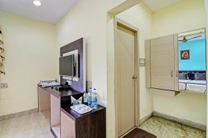 Habitación de hotel con baño con lavabo y TV. en OYO Flagship Hotel Night Owl, en Durgāpur