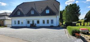 a large white house with a black roof at Fewo Traum in Neppermin