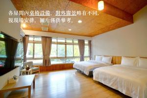 1 dormitorio con 2 camas y ventana grande en TokuGawa Hotel, en Shuili