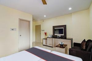 Habitación de hotel con cama y TV en OYO Flagship Hotel Night Owl, en Durgāpur