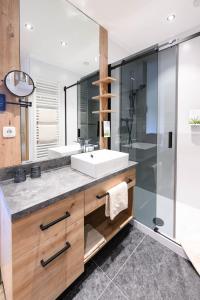 a bathroom with two sinks and a glass shower at Hotel Sonnfeld in Hinterstoder