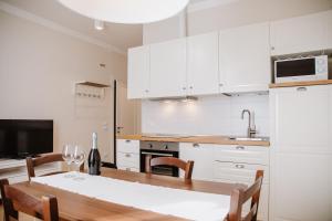 een keuken met witte kasten en een tafel met stoelen bij Prosecco Collalto Lodge in Susegana