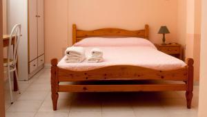 a bedroom with a wooden bed with towels on it at Paradise Studios in Svoronata