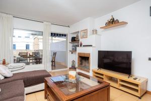 a living room with a couch and a television at House 5 Mins From Montgat Beach in Montgat