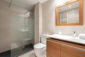 ein Badezimmer mit einem WC, einem Waschbecken und einem Spiegel in der Unterkunft House 5 Mins From Montgat Beach in Montgat