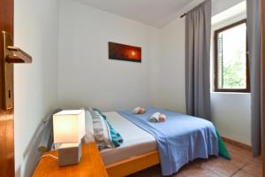 een kleine slaapkamer met een bed met een blauwe deken bij Apartment Zivko 2331 in Fažana