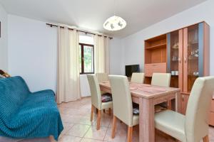 een eetkamer met een houten tafel en stoelen bij Apartment Zivko 2331 in Fažana