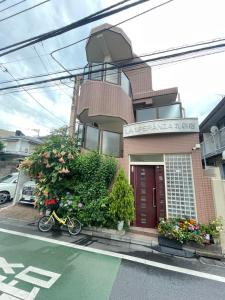 東京にある都心の家-ダブルベットと畳み3人部屋の建物前に駐輪する自転車
