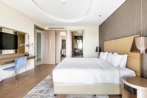 een slaapkamer met een groot wit bed en een bureau bij Paramount High Floor 1 bedroom apt in Dubai