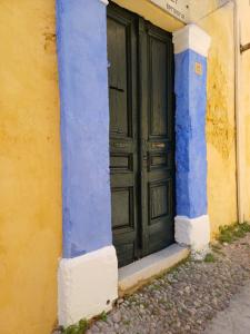 ein blaues und gelbes Gebäude mit grüner Tür in der Unterkunft Rhodes Youth Hostel in Rhodos (Stadt)