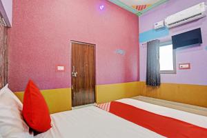 um quarto com 2 camas e almofadas vermelhas em Hotel Dwarka em Alīgarh