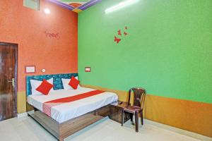 um quarto com uma cama e uma parede verde em Hotel Dwarka em Alīgarh