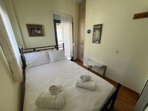 a bedroom with a bed with towels on it at Cate's Apartment in Hanioti +2 photos