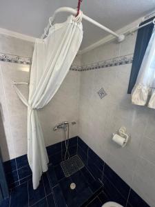 a shower curtain in a bathroom with a toilet at Cate's Apartment in Hanioti