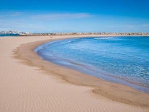 una playa con el océano y la costa en Habitaciones de Hostal a Primera linea de playa en Cullera, en Cullera