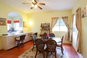 jadalnia ze stołem i krzesłami oraz kuchnia w obiekcie Bliss home w mieście Saint James
