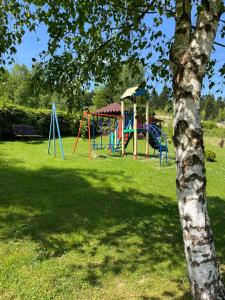 un parque infantil con un árbol en Guest House U Sester, en Skhidnytsya