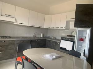 a kitchen with white cabinets and a table and chairs at Appartamento 300m dal mare AMANTEA CALABRIA in Amantea +22 photos