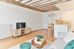 uma sala de estar com um sofá e uma mesa em Appartement Quartier Saint-Germain em Paris