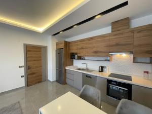 a kitchen with wooden cabinets and a table and chairs at SA Apartments! 1bd Flat 300m to the Beach in Alanya