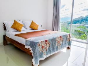 a bedroom with a bed with a blanket on it at Flaming Tree Resorts in Kiriwan Eliya