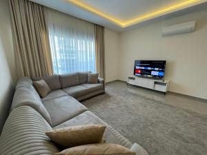 a living room with a couch and a flat screen tv at SA Apartments! 1bd Flat 300m to the Beach in Alanya
