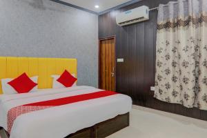 1 dormitorio con 1 cama grande con almohadas rojas en OYO Flagship Ideal Inn en Lucknow