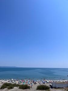 uma praia com muitos guarda-sóis e o oceano em Petar and Pavel Hotel & Relax Center em Pomorie