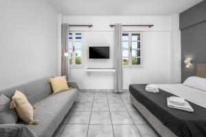 a living room with a couch and a tv at Cleomenes Old Town Studios in Rhodes Town