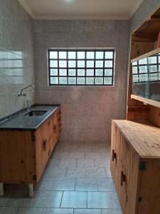 a large kitchen with a sink and a window at Cute Rustic Cottage by the River in Caximba
