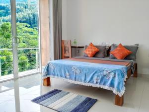 a bedroom with a bed and a large window at Flaming Tree Resorts in Kiriwan Eliya