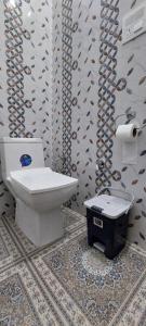 a bathroom with a toilet and a trash can at Virasat E Punjab -Farmstay Amritsar in Nūruddīn