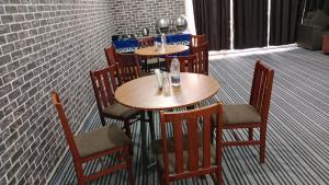 TIPSYY INN 007 في جورجاون: مجموعة طاولات وكراسي في مطعم