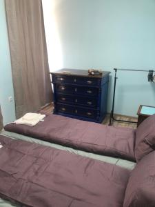 a bed in a room with a dresser and a bed sidx sidx at Тракия 3А in Shumen