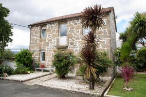 a stone house with palm trees in front of it at Casa San Martiño - Teo in Rua De Francos