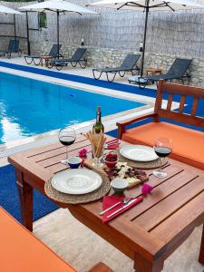 a table with glasses of wine and food next to a pool at Özgüm Suite Otel in Datca