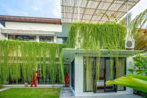 a building with green ivy on the side of it at Lush 3 BR enclose living room next to Canggu beach in Canggu