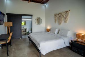 a bedroom with a large white bed and a desk at Lush 3 BR enclose living room next to Canggu beach in Canggu