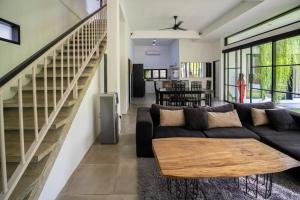 a living room with a couch and a staircase at Lush 3 BR enclose living room next to Canggu beach in Canggu